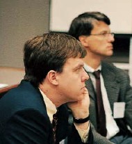 Stuart Ray (forefront) and Maurizio Bonacini listen to a presentation by Barbara McGovern on treatment of HIV-HCV coinfection.