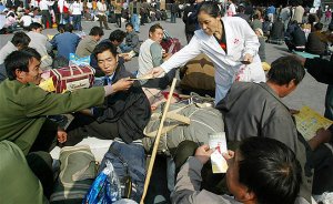 A Chinese medical worker hands out leaflets on AIDS to migrant workers at a train station in Guangzhou, the capital of China's southern province of Guangdon.