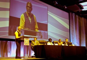 Phill Wilson of the Black AIDS Institute addresses the closing plenary. Listening are (l-r) CDC's Dr. Rich Wolitski, Dr. Marjorie Hill of GMHC, Michelle Lopez of NAPWA, and Dr. Ron Valdiserri of HHS. Photo credit: Larry Bryant, HousingWorks.